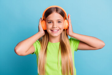 Sticker - Photo of young cheerful positive good mood smiling girl wearing orange headphones listen music isolated on blue color background