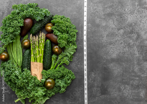 Diet and healthy background with green vegetables and measure tape. © Jane Vershinin