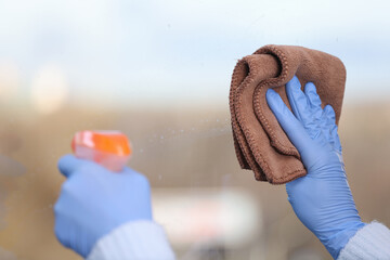 Wall Mural - Man washes window and holds rag and cleaning agent. Services of cleaning companies concept