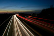 Autos auf der Autobahn bei Nacht. Langzeitbelichtung mit Straßenverkehr mit Scheinwerfern im Dunkelheit