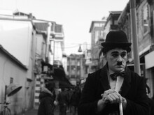 Man Imitating Charlie Chaplin Standing On Street