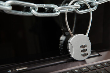 Closeup of laptop with chains and lock. Information security concept.