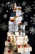 A Lot Of Christmas Gifts Are Packed In Boxes In The Form Of A Xmas Tree On A Dark Background With Snowflakes.