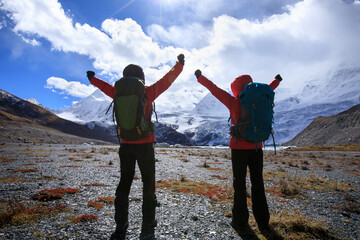 Wall Mural - Two women hikers hiking  in winter mountains