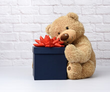 Big Teddy Bear And Blue Square Cardboard Box With Red Bow