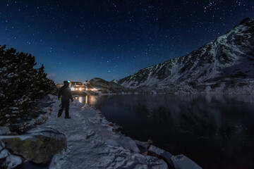 Wall Mural - Starry sky in winter Polish Tatras near a mountain lake covered with ice
