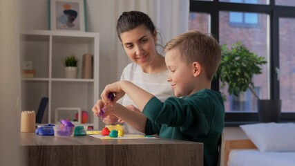 Canvas Print - family, creativity and craft concept - mother and little son making picture of modeling clay at home