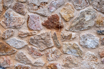 Wall Mural - Stone wall background and texture, pink red stones built surface