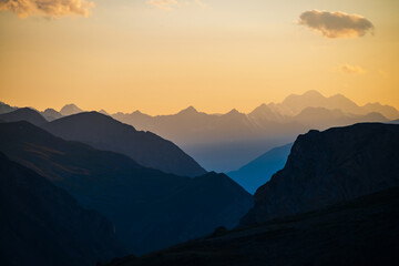 Wall Mural - colorful dawn landscape with beautiful blue mountains silhouettes and golden gradient sky with cloud