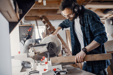 Wall Mural - Wood cutting with circular saw. Closeup of mature man sawing lumber.