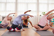 © Monkey Business - Group With Teacher Sitting On Exercise Mats Stretching In Yoga Class Inside Community Center