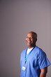 © Monkey Business - Studio Portrait Of Male Nurse Wearing Scrubs Standing Against Grey Background