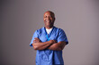 © Monkey Business - Studio Portrait Of Male Nurse Wearing Scrubs Standing Against Grey Background