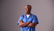 © Monkey Business - Studio Portrait Of Male Nurse Wearing Scrubs Standing Against Grey Background