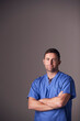 © Monkey Business - Studio Portrait Of Male Nurse Wearing Scrubs Standing Against Grey Background