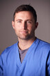 © Monkey Business - Studio Portrait Of Male Nurse Wearing Scrubs Standing Against Grey Background