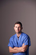 © Monkey Business - Studio Portrait Of Male Nurse Wearing Scrubs Standing Against Grey Background