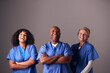 © Monkey Business - Studio Portrait Of Three Members Of Surgical Team Wearing Scrubs Standing Against Grey Background