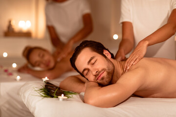 Relaxed Couple Enjoying Massage And Herbal Aromatherapy In Spa