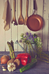 verduras en una cocina rustica, con paredes de tabla en blanco y encimera de color azul envejecido