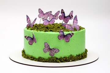 Beautiful tasty green cake with butterflies on a white background