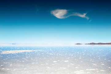 Wall Mural - White salt surface with water in Salar de Uyuni salt flat in Bolivia. South America landscapes.