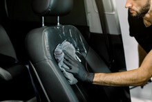 Cropped Image Of Hand Of Auto Service Worker, In Black Rubber Glove, Cleaning Car Interior, Car Front Seat With Microfiber Clothes And Cleansing Foam. Car Detailing And Valeting Concept