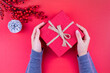 hands holding gift box in red new year concept with Christmas ornaments