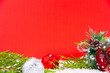 Close up new year decoration on a red background; pine tree, shiny ornaments and candles for Christmas like celebration card