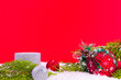 new year decoration on a red background; pine tree, shiny ornaments and candles for Christmas like celebration card