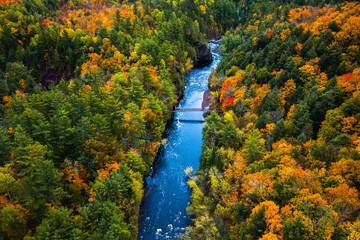 Wall Mural - beautiful travel aerial of a pedestrian foot bridge crossing the bright blue water of the bad river 
