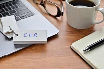 Leinwandbilder - On a desk with a laptop, glasses, coffee, and a notebook, a vocabulary book was placed open There. The word CVR is there. It's an acronym that means Conversion Rate.