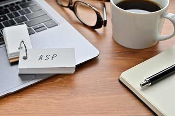 Poster - On a desk with a laptop, glasses, coffee, and a notebook, a vocabulary book was placed open There. The word ASP is there. It's an acronym that means Application Service Provider.