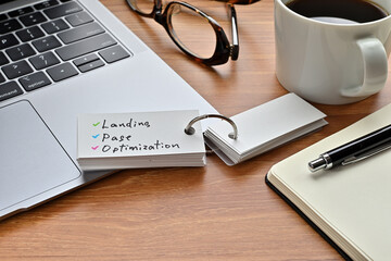 Leinwandbilder - There is a piece of paper with a graph printed on it, a clipboard, and an open vocabulary book on the desk. There is the word Landing Page Optimization on it.