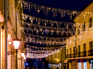 Wall Mural - christmas illumination on old street in Minsk. night street on christmas eve.