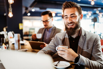 Wall Mural - Cheerful businessmen using laptop at the meeting