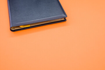 Sticker - Top view closeup of a grey notebook with a yellow bookmark isolated on an orange background