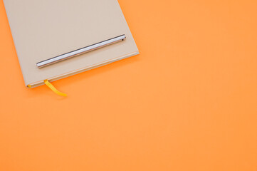 Sticker - Top view closeup of a grey notebook with a yellow bookmark isolated on an orange background