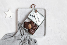 Chocolate Candy With Nuts And Dates In Gift Box On White Marble Background