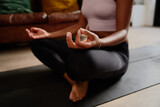 Fototapeta  - Closeup of hands of young woman sitting in lotus position meditating in the lotus pose at home