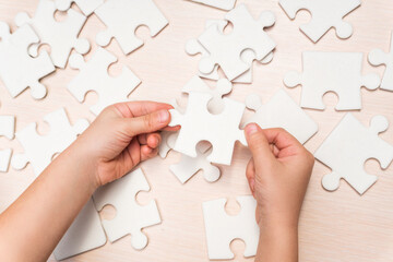 a child's hand makes the last missing piece of the puzzle. business concept