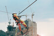 Abseiling worker on high wear dresses and safety man with harness concept on steel structures success from work in site construction on blue sky background on retro filter tone.