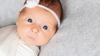 closeup portrait of cute newborn caucasian baby. adorable funny infant child with dark gray eyes and