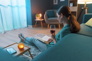 Woman reading a book and drinking wine