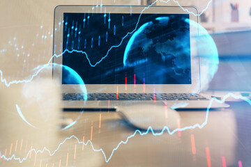 Financial chart drawing and table with computer on background. Multi exposure. Concept of international markets.