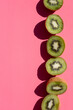 © Foodlovers - A row of kiwi halves on a pink background