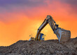 Excavator working on earthmoving at open pit mining on amazing sunset background. Backhoe digs sand and gravel in quarry. Heavy construction equipment during excavation at construction site
