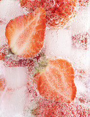 Wall Mural - Closeup shot of a refreshing drink with a slice of strawberries and ice cubes