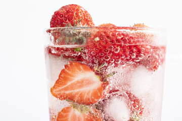 Sticker - Closeup shot of a refreshing drink with a slice of strawberries and ice cubes