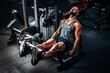 © VlaDee - Muscular man using weights machine for legs at the gym. Hard training